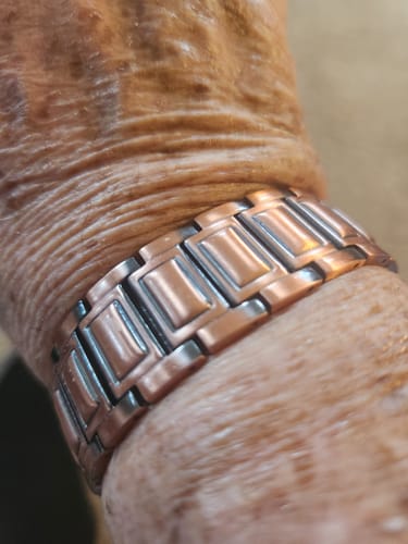 Customer's copper bracelet worn on their wrist, showing the wide metallic links