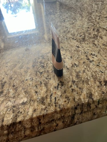 Customer's Foundation tube shown from a side angle on a granite countertop, highlighting its flat, slim shape.