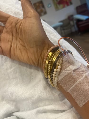 Customer's STACKER bracelets in gold, rose gold, onyx, and white tones worn on a person's wrist.