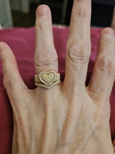 Customer's Stackable 3-Piece Ring Set featuring a beige heart ring with CZ stones worn on a finger.