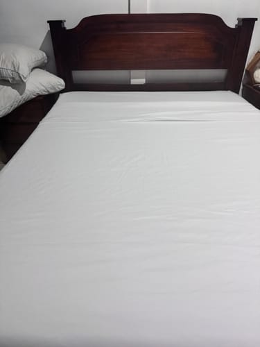 Customer's Colchón Ortopédico Clásico, a white mattress placed on a wooden bed frame.