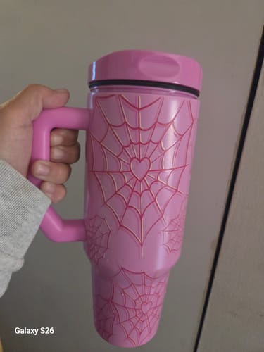 Customer's pink Frost Buddy cup with spiderweb patterns held in a hand