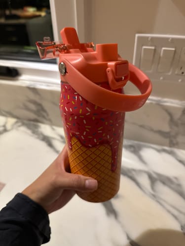Reviewer's hand holding the Pink Ice Cream Bottle Buddy with a colorful waffle cone pattern.