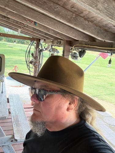 Reviewer's wide brim felt hat on their head, shown from a side profile outdoors.