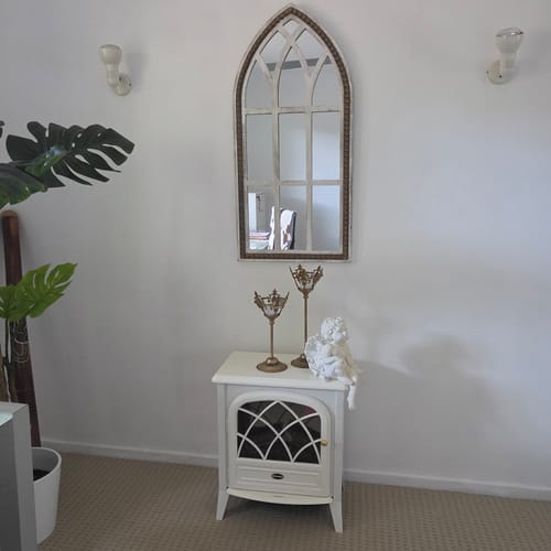 Customer's Antoine French Provincial cherub figurine displayed on a white side table next to two tall candle holders.