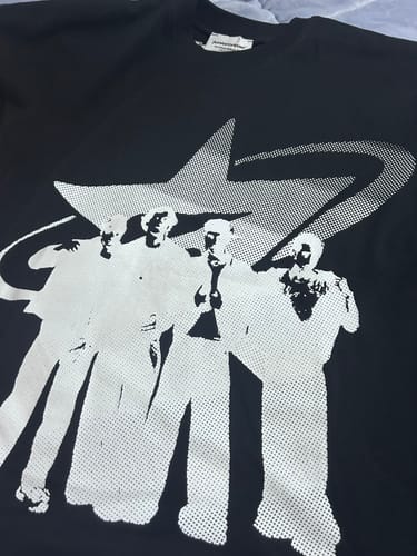 Customer's Radikal Merch siyah boxy tişörtün ön yüzü, üzerinde beyaz noktalı figür baskısı görünüyor.