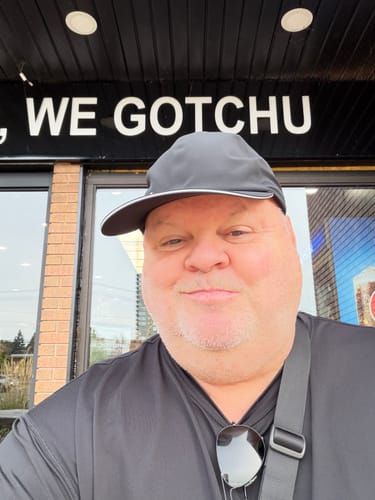 Customer's Big Running Hat, close-up selfie in front of a building.