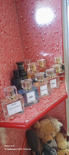 Customer's Oud Serene perfume displayed on a shelf among a collection of various fragrance bottles.
