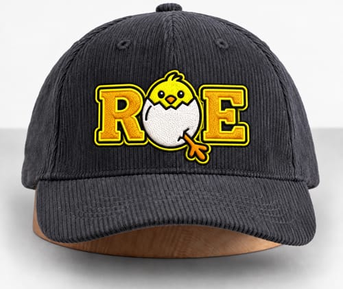 Customer's charcoal corduroy baseball cap with custom embroidered chick logo, placed on a wooden display base.
