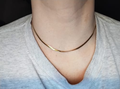 Customer's gold-toned Chelsea Herringbone Necklace worn as a choker around a person's neck.