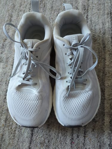 Customer's pair of Flow wide toe box everyday walking shoes in light gray on a carpeted floor.