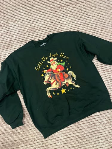 Customer's dark green Giddy Up Jingle Horse sweatshirt with a western-style cowboy illustration and festive text.