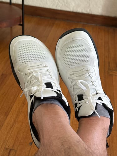 Customer's white CUURT Muuv wide toe box court shoes on feet, showing the comfortable fit.