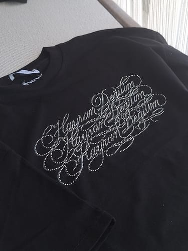 Customer's black Radikal Merch Hayran Değilim t-shirt with sparkly stone-embellished lettering.