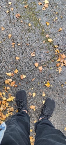 Reviewer's black Vaistoa Rento 2 -paljasjalkatennarit asettuna päällystetylle tielle, jossa on syksyisiä lehtiä.