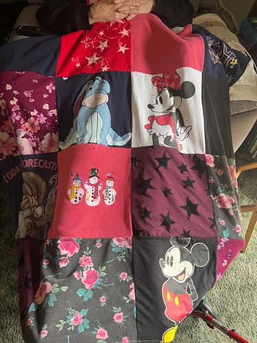 Customer's Project Repat T-Shirt Quilt featuring squares with Disney characters, snowmen, and floral patterns.