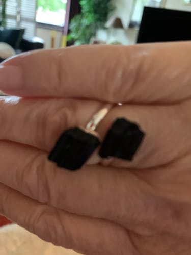 Customer's bague avec deux pierres de Tourmaline noire brutes portée sur le doigt, vue rapprochée.