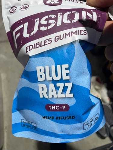 Customer's hand holding a blue Fusion Gummies Blue Razz THC-P pouch.
