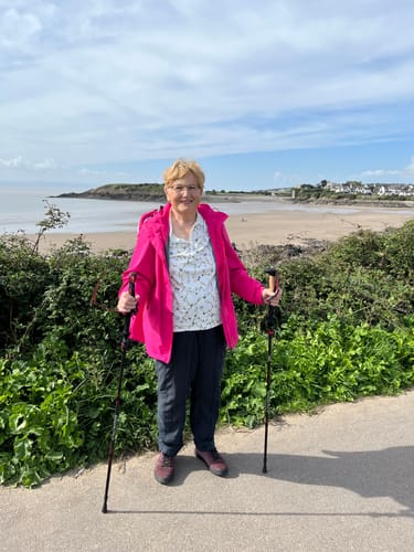 Reviewer's Wanderstöcke Rugova Pro 3 hiking poles used for support while standing outside by the beach.