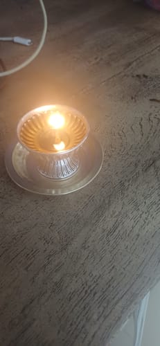 Customer's Shine Lock cleaned brass lamp lit and glowing on a wooden table.
