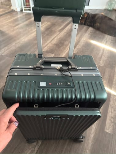 Customer's green NOBL luggage with an open exterior pocket and a visible USB charging cable.