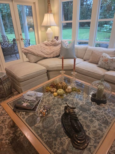 Customer's light-colored Hugs Creme Brulee Blanket draped over a neutral living room sofa.