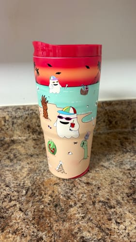 Customer's Sunscream To-Go Buddy tumbler with a summer ghost pattern, standing on a kitchen counter.