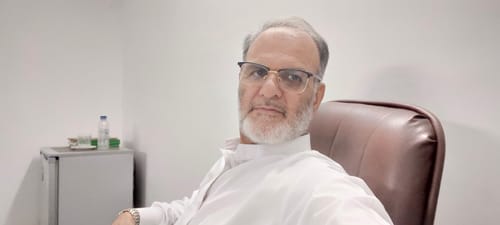 Customer, wearing a white shirt and glasses, sharing a positive experience with The Royal Oud Collection.