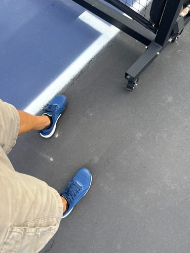 Customer's blue CUURT Muuv court shoes being worn on a pickleball court.
