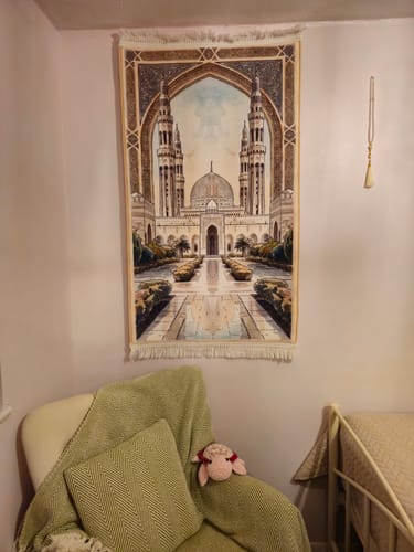 Customer's Madinah Grace Padded Prayer Mat hanging on a wall as decor in a cozy room.