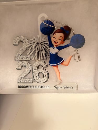 Customer's personalized cheerleader acrylic ornament with the name Ryan Harris and Broomfield Eagles shown in a box.