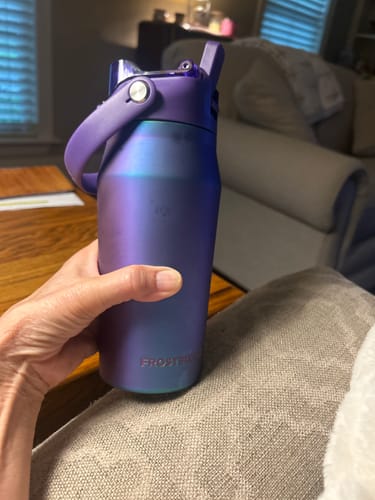 Reviewer holding a purple Bottle Buddy water bottle, highlighting its compact size in their hand.