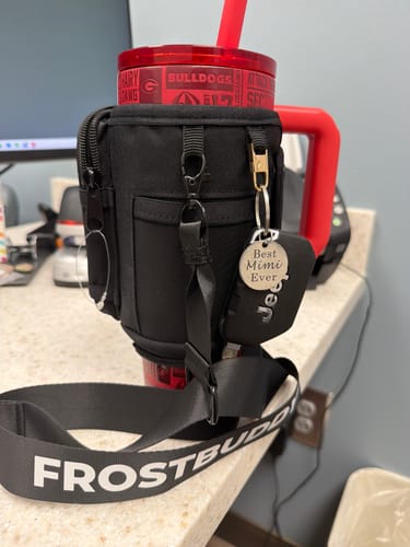 Customer's Georgia Bulldogs Thicc Buddy tumbler with black carrying sleeve, hanging keys, and strap on a counter.