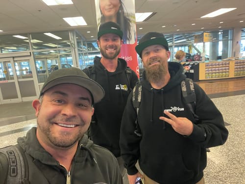 Reviewer's three people posing for a selfie in a public indoor setting, unrelated to the ICON 102/105mm LS Cable Drive Throttle Body.