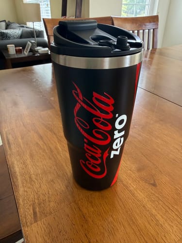Customer's black Coca-Cola Coke Zero To-Go Buddy tumbler sitting on a wooden table.