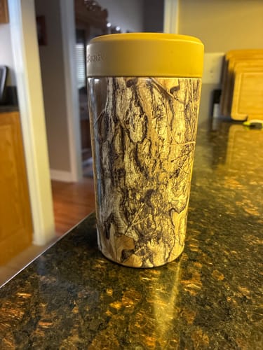 Customer's Universal Buddy 2.0 beverage cooler with a tan lid and camouflage patterned body on a counter.