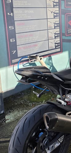 Customer's BMW S1000RR rear tail section featuring the integrated LED light installed, parked at a wash station.