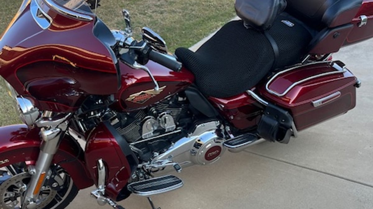 Wind Rider 3D mesh seat cover installed on a red Harley-Davidson Ultra Limited with hard saddlebags and tour pack, parked in a driveway