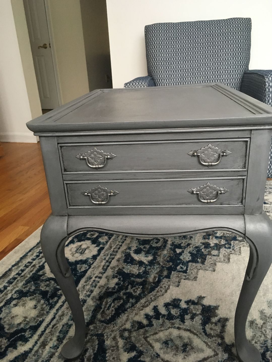 Painted a dark wood end table with grey paint and used the black wax