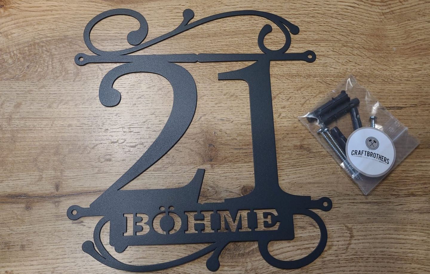 Customer photo review of Hausnummer Türschild mit Ornament und Familiennamen aus edlem Stahl