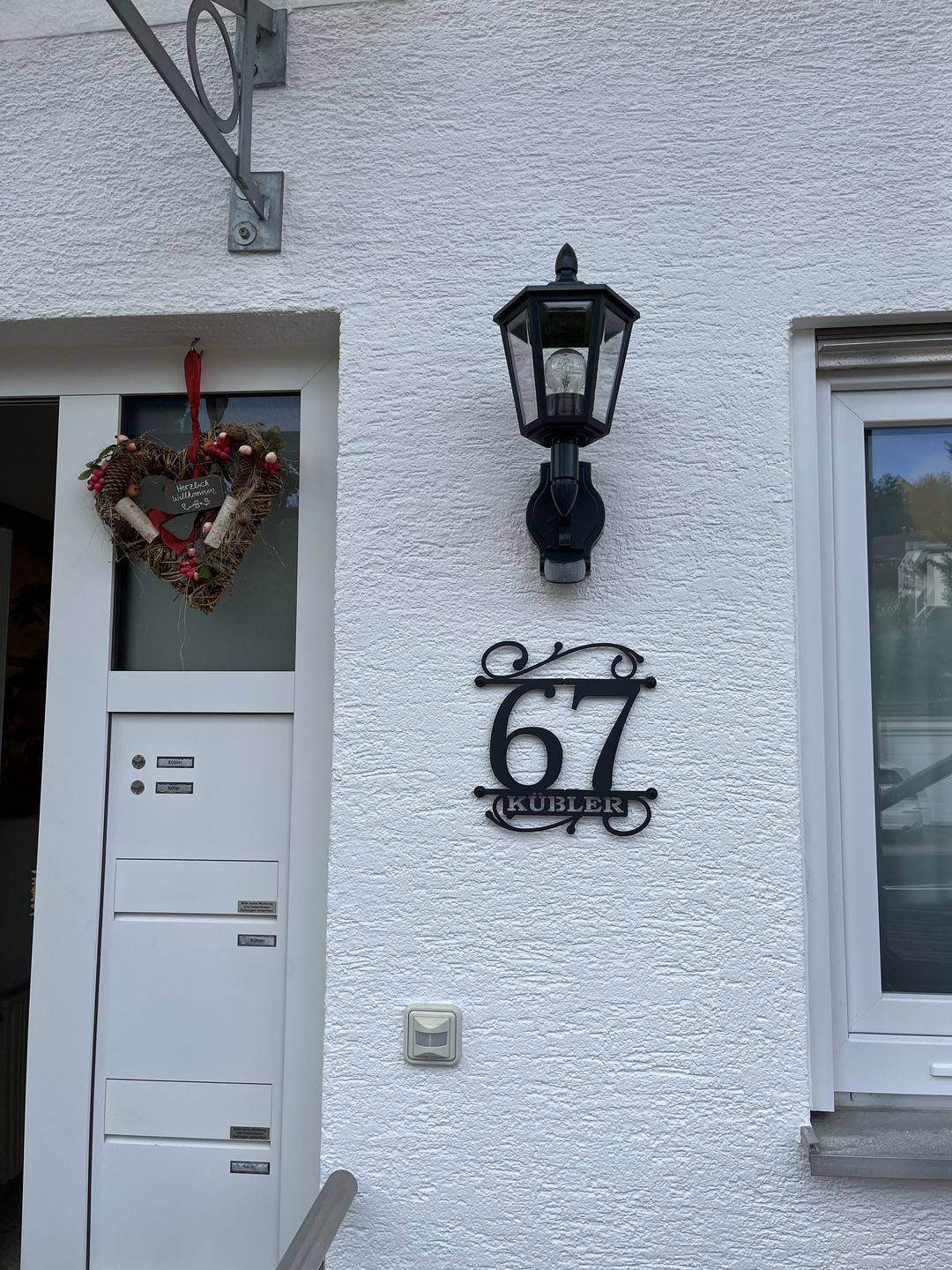 Customer photo review of Hausnummer Türschild mit Ornament und Familiennamen aus edlem Stahl