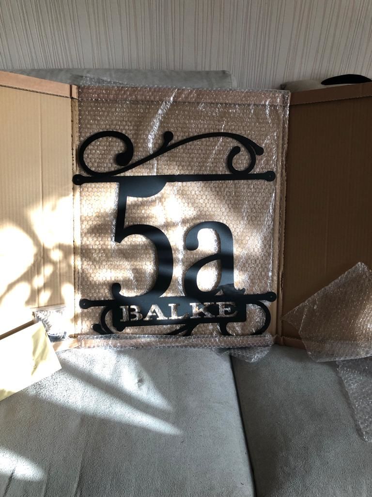 Customer photo review of Hausnummer Türschild mit Ornament und Familiennamen aus edlem Stahl