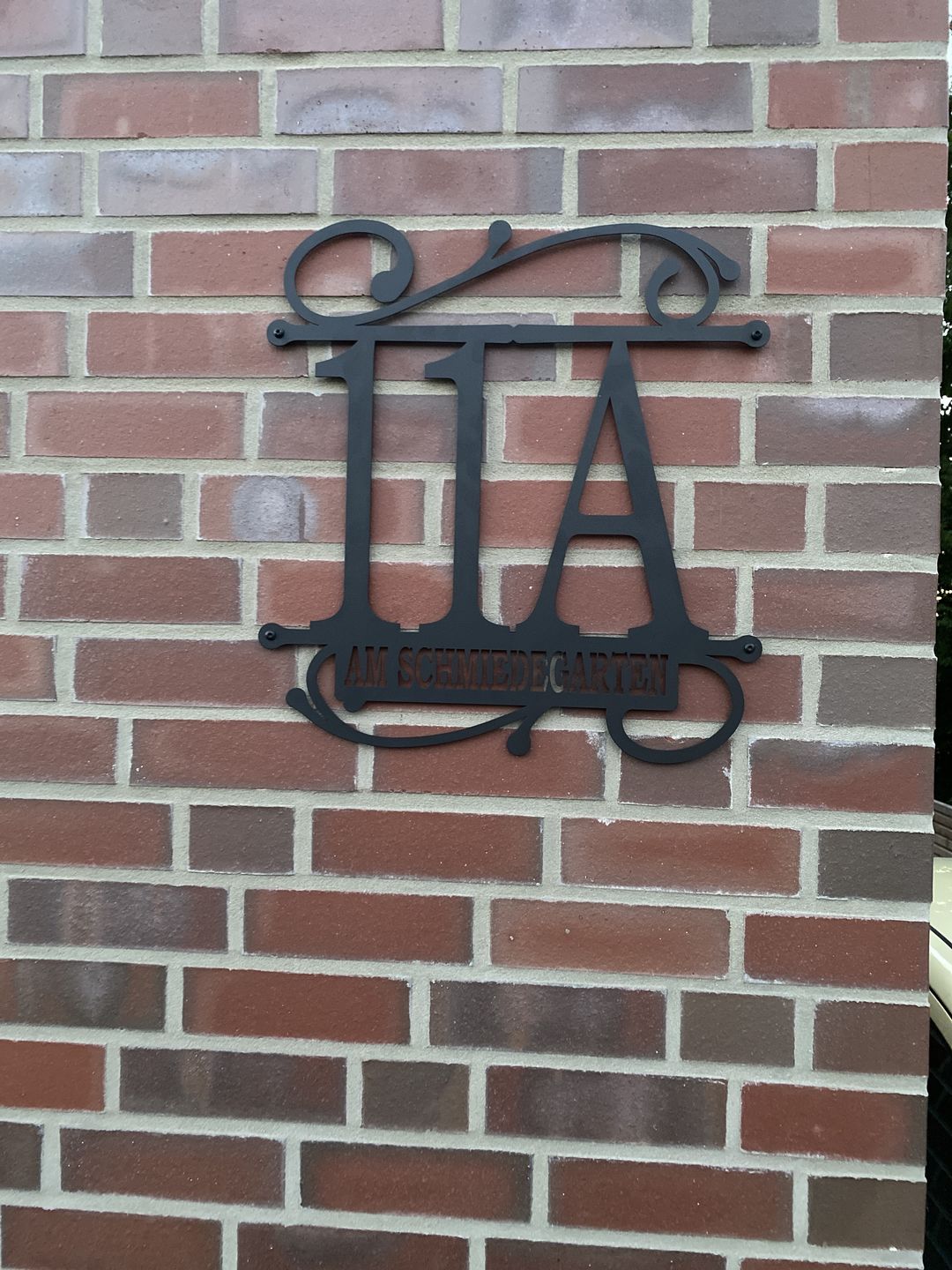 Customer photo review of Hausnummer Türschild mit Ornament und Familiennamen aus edlem Stahl