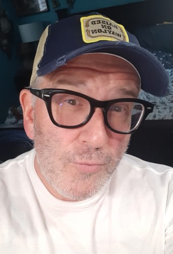 Customer photo review of Raised on Waylon Jennings Distressed Navy Trucker Hat