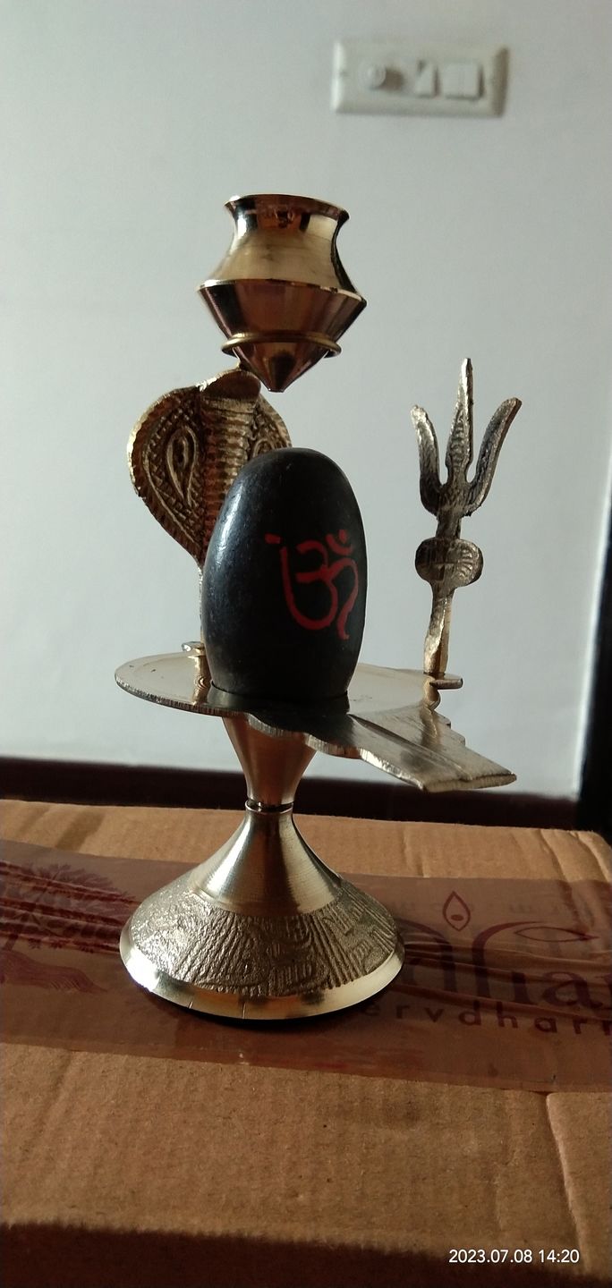 Customer photo review of Natural Stone Narmadeshwar Shivling with Small Golden Trishul & Temple Figurine (6 Inch)