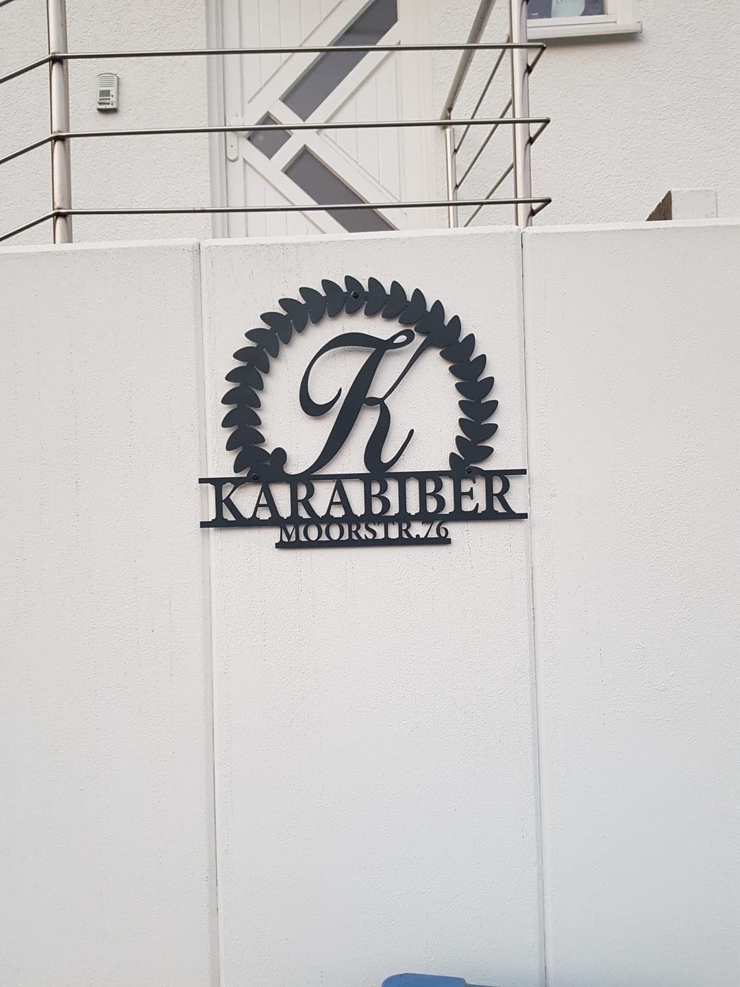 Customer photo review of Hausnummer Türschild mit Ornament und Familiennamen aus edlem Stahl