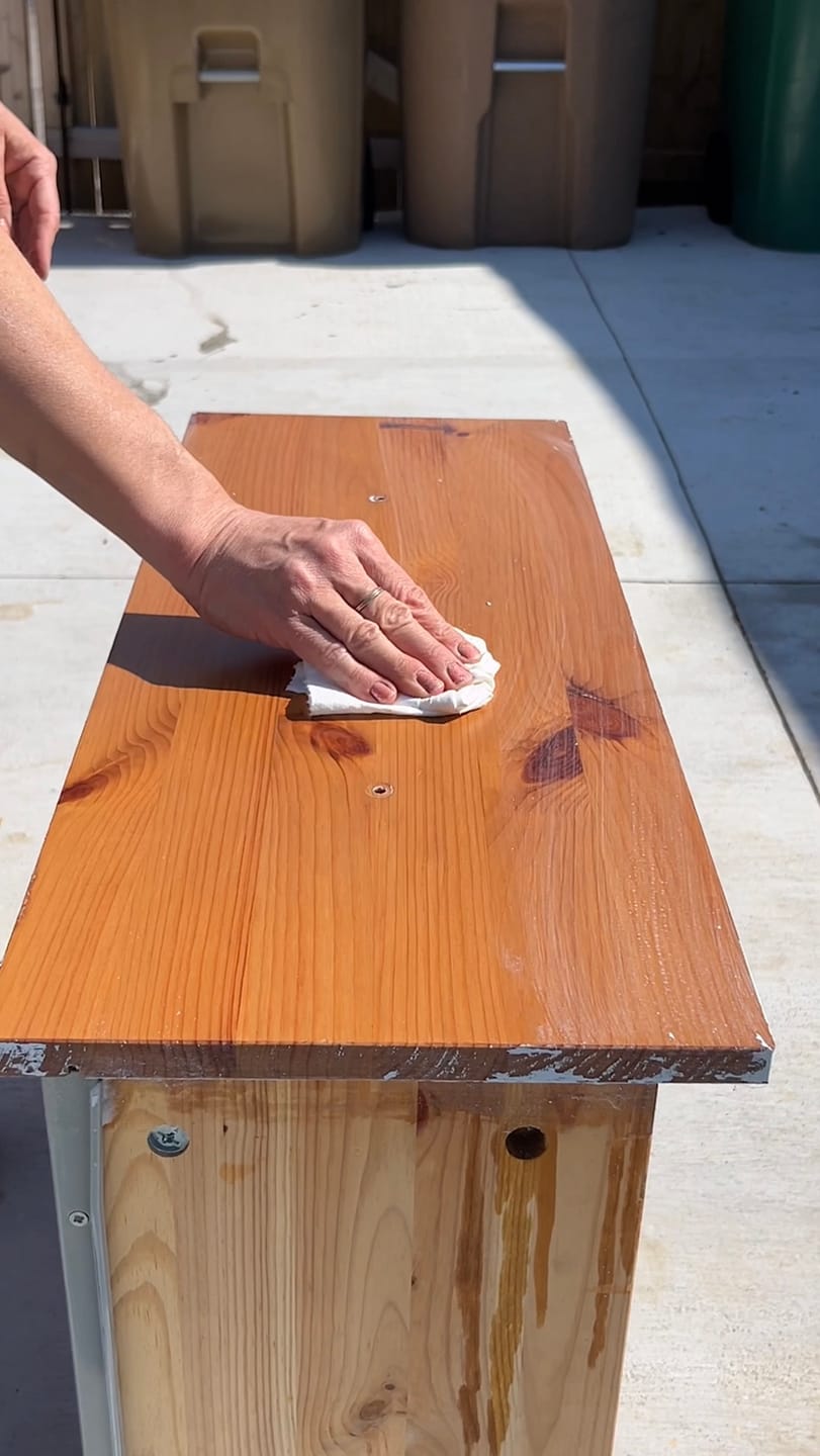 A customer wiping a freshly stripped drawer top clean