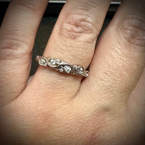 Customer photo review of Bezel Set Round Moissanite Scroll Accents Wedding Band Ring In Sterling Silver