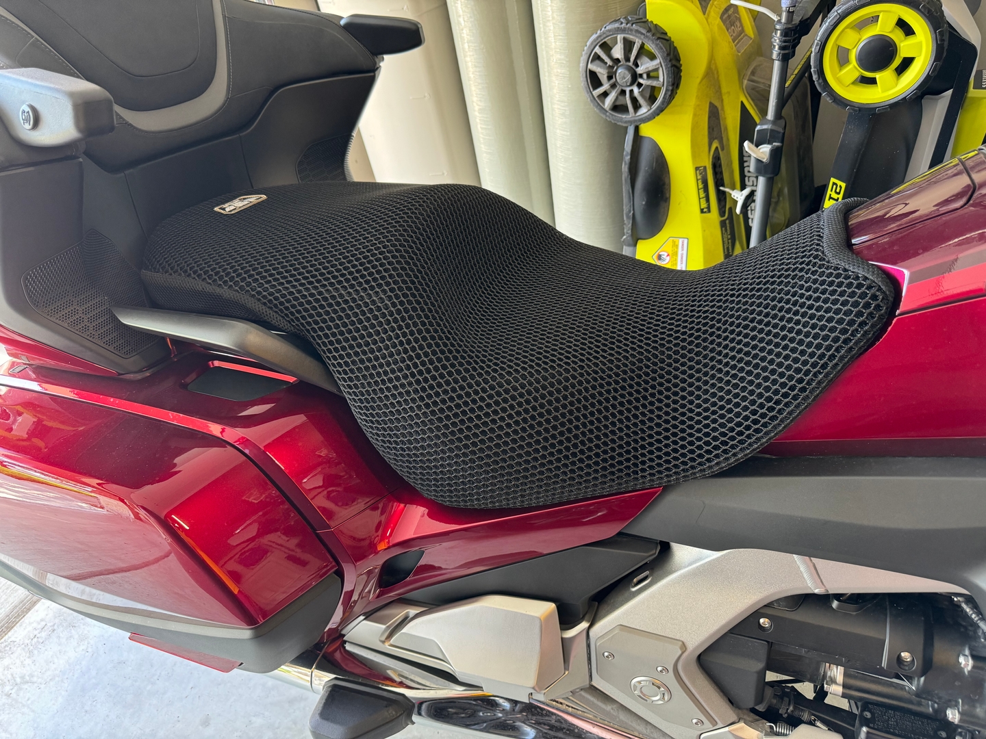 Wind Rider mesh seat cover installed on the rider seat of a red Honda Gold Wing, honeycomb texture clearly visible