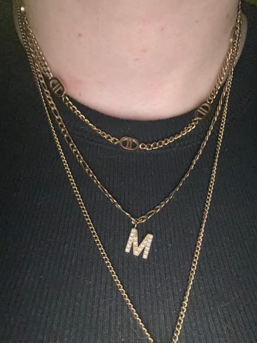 Nahaufnahme einer Person, die die goldfarbene Prestige 2 Halskette als Teil eines Lagenlooks trägt.